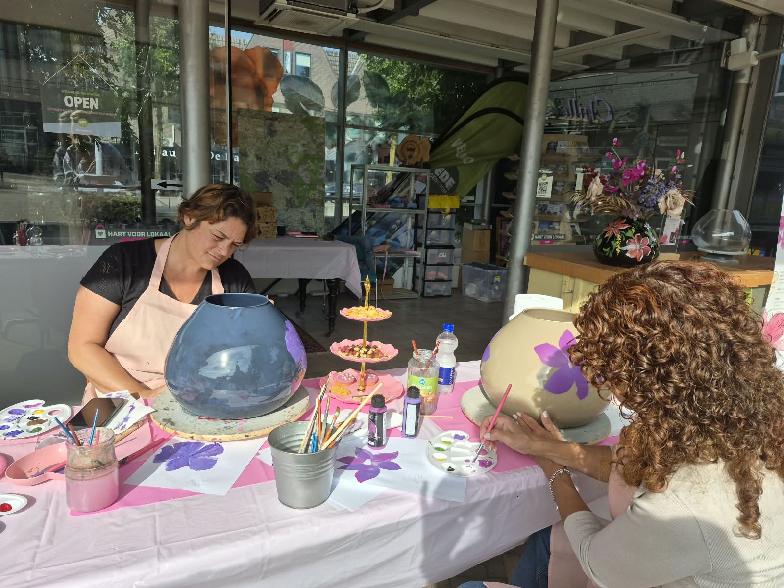 Deelnemers schilderen vazen tijdens een workshop